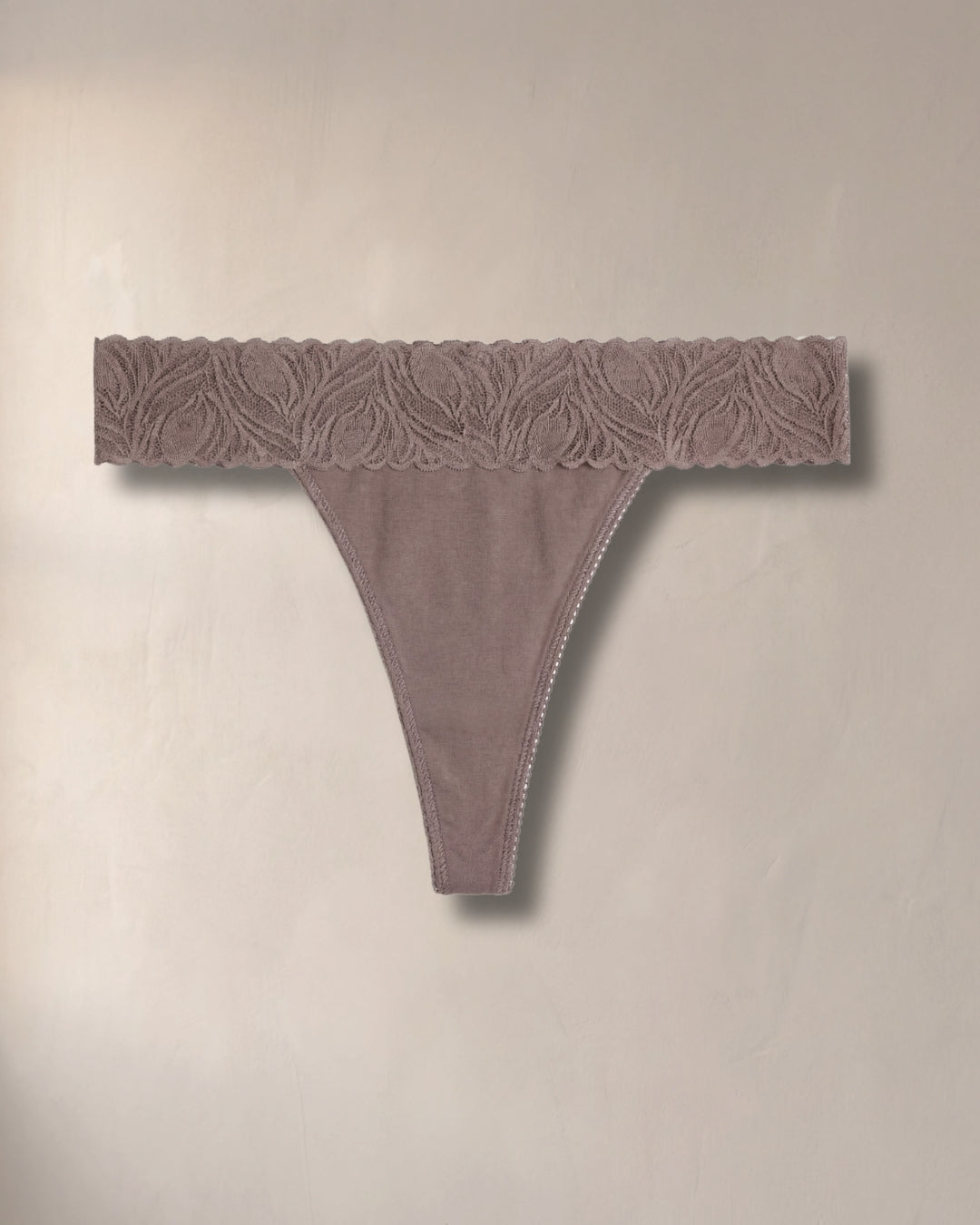 true taupe lace thong on a beige background from camofleur