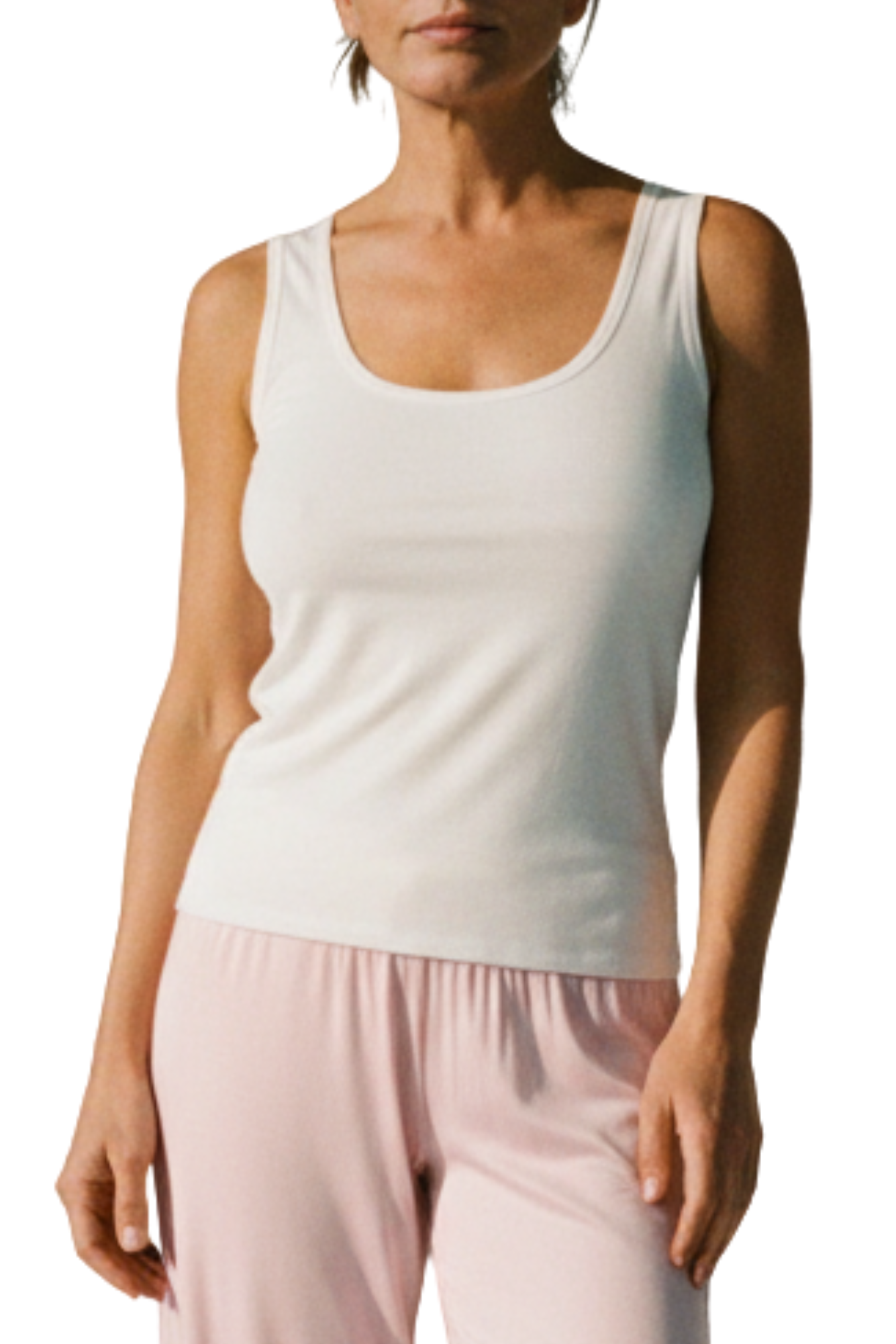 Woman wearing a white ribbed tank top and pink sleep + lounge pants made of bamboo and cotton from Camofleur on a white background