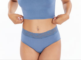 Woman wearing a blue sports bra and high-waisted underwear set on a white background