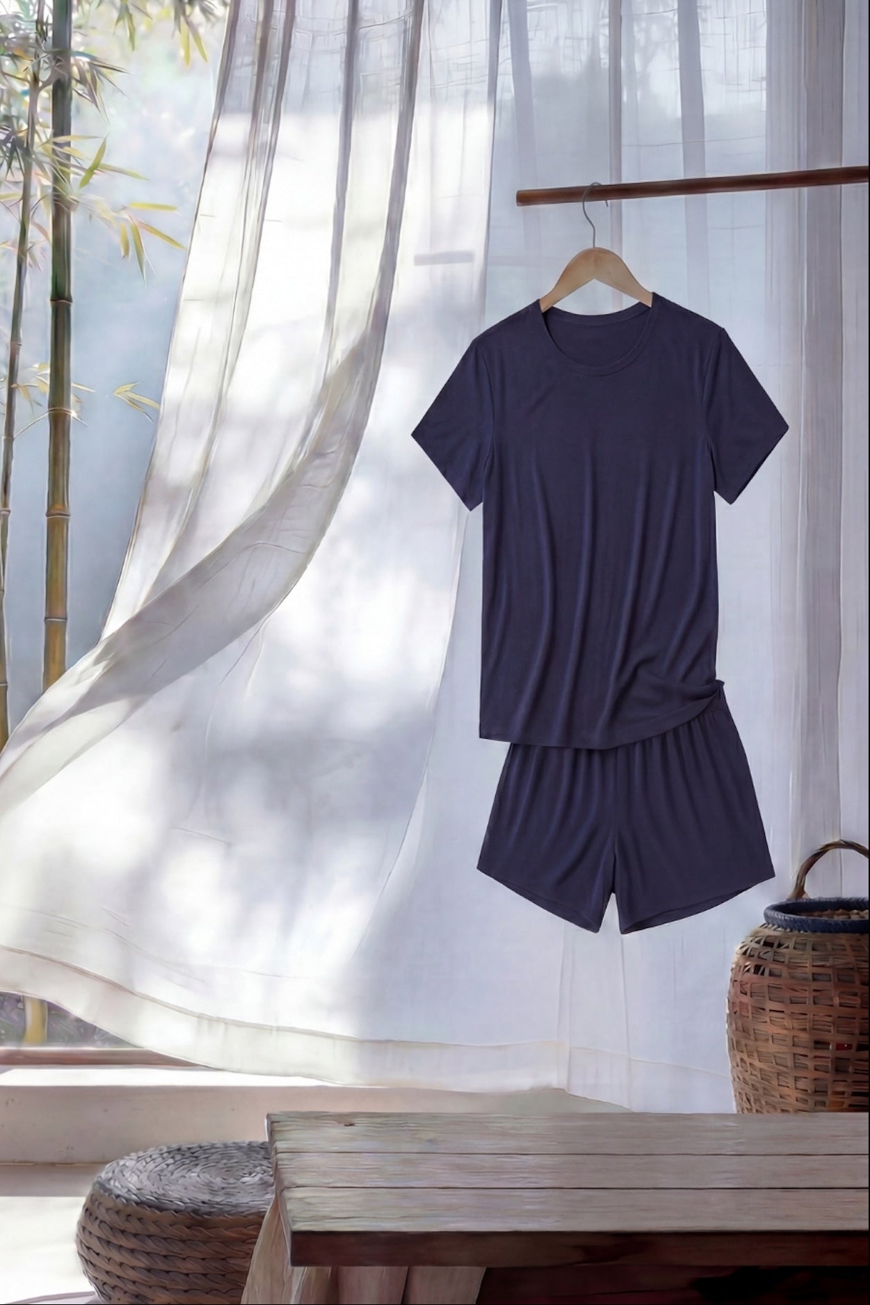 Navy blue t-shirt and shorts set hanging against a light curtain with bamboo background